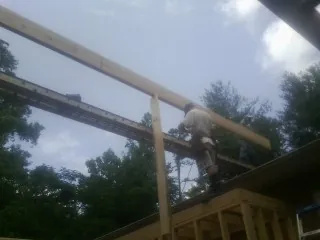 Carpenter setting a ridge beam over a new addition frame — Ice Dam Removal by Roofing Brothers in Waynesboro